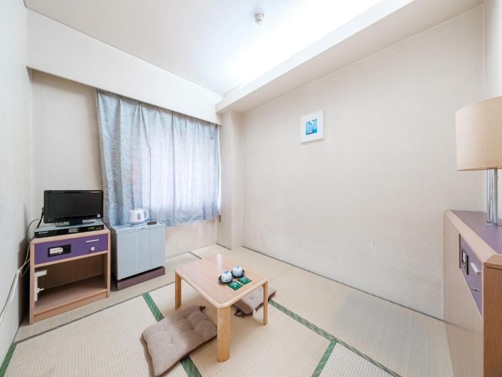 una pequeña sala de estar con TV y mesa. en Hotel Tetora Spirit Sapporo - Vacation STAY 59369v, en Sapporo