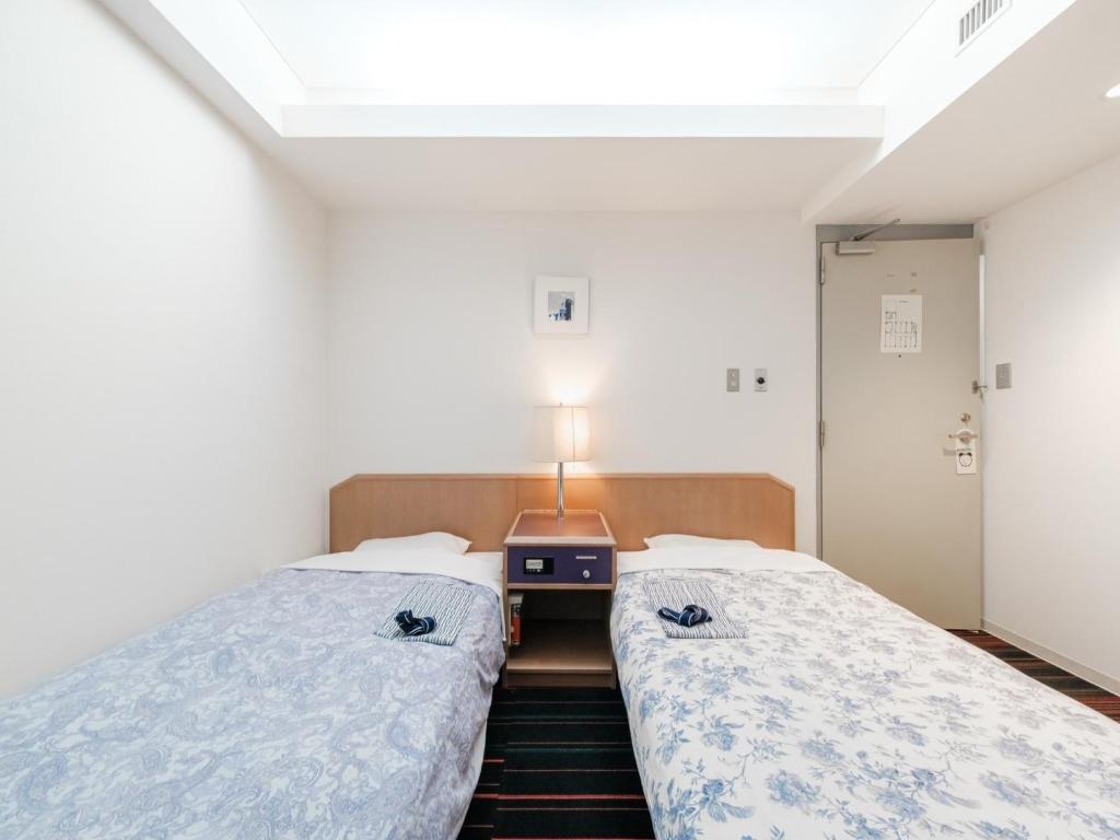 札幌的住宿－Hotel Tetora Spirit Sapporo - Vacation STAY 59346v，客房设有两张床和一张带台灯的桌子。