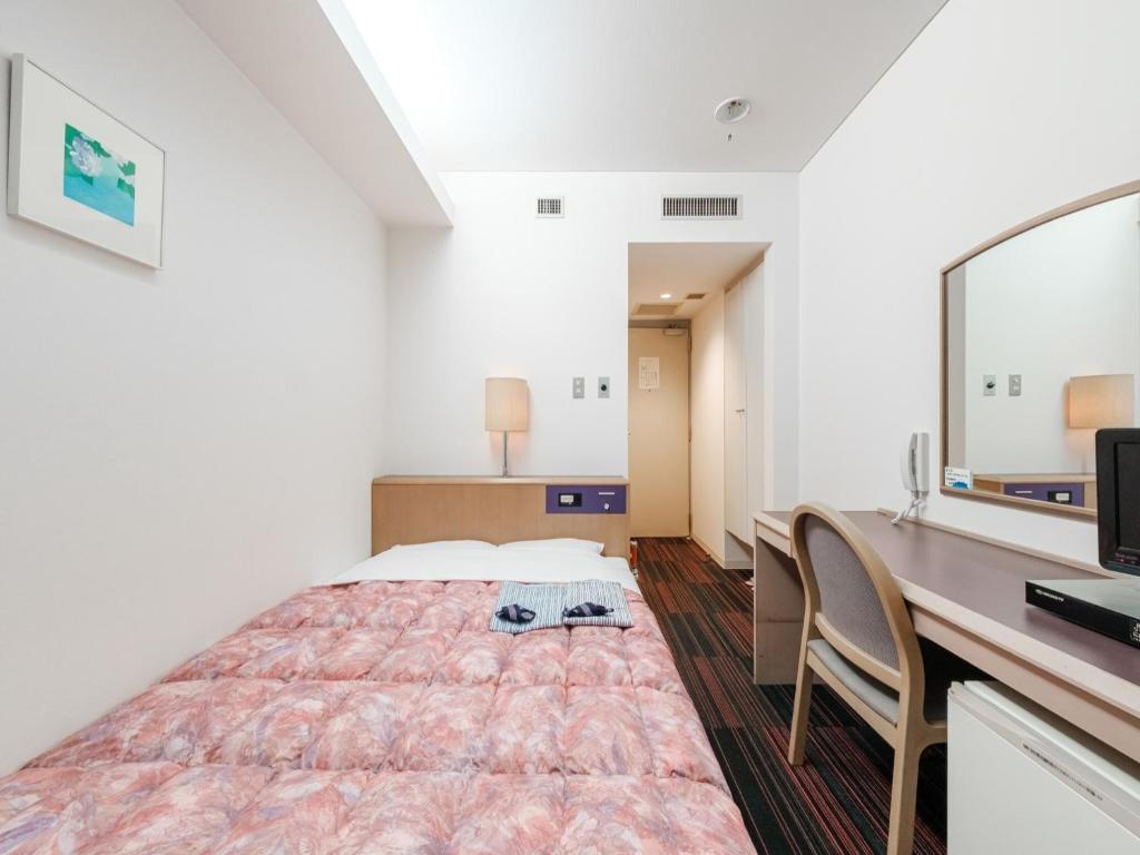 a bedroom with a bed and a desk and a television at Hotel Tetora Spirit Sapporo - Vacation STAY 59361v in Sapporo
