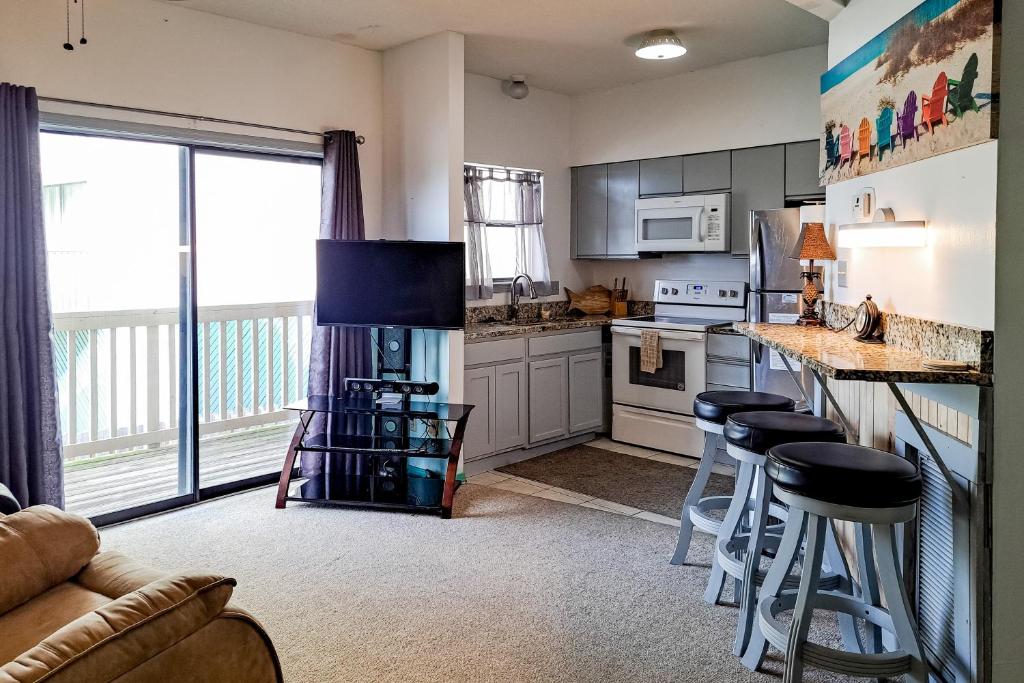 a kitchen with a counter and stools in a room at Lei Lani Village 103 in Orange Beach