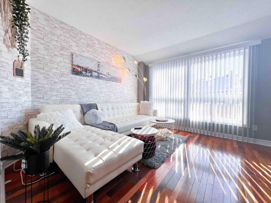 un soggiorno con divano bianco e parete di mattoni di Fully furnished Townhome with Driveway Near DT a Ottawa