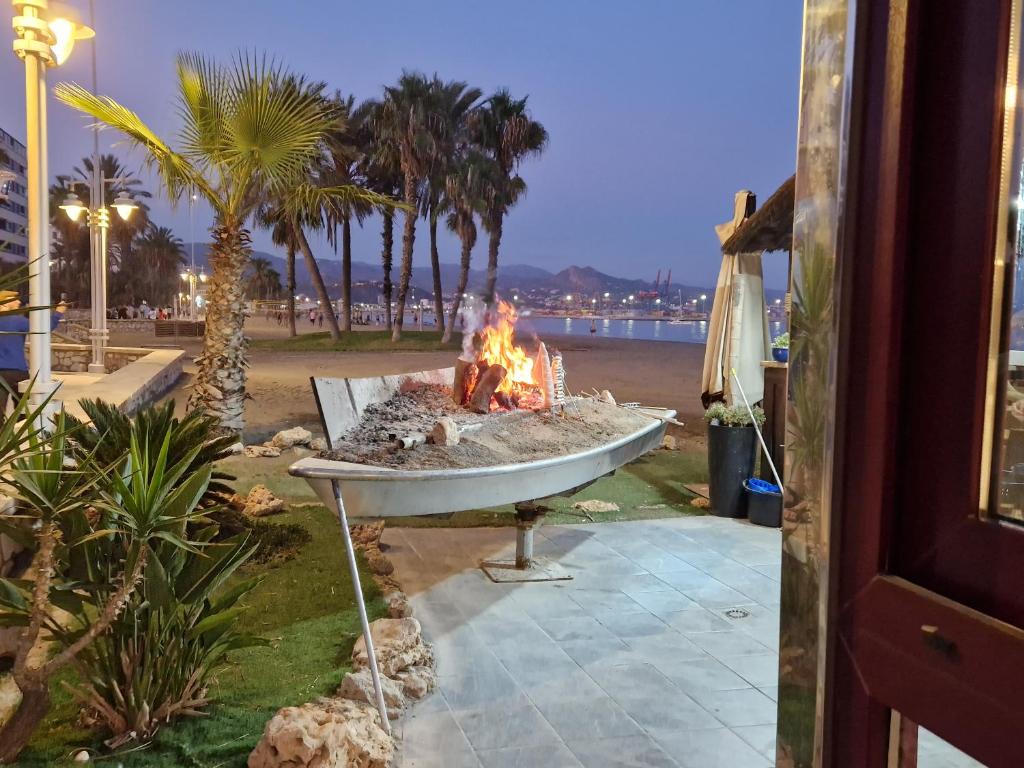 a fire in a bath tub next to a beach at APARTAMENTO ABADIA in Málaga