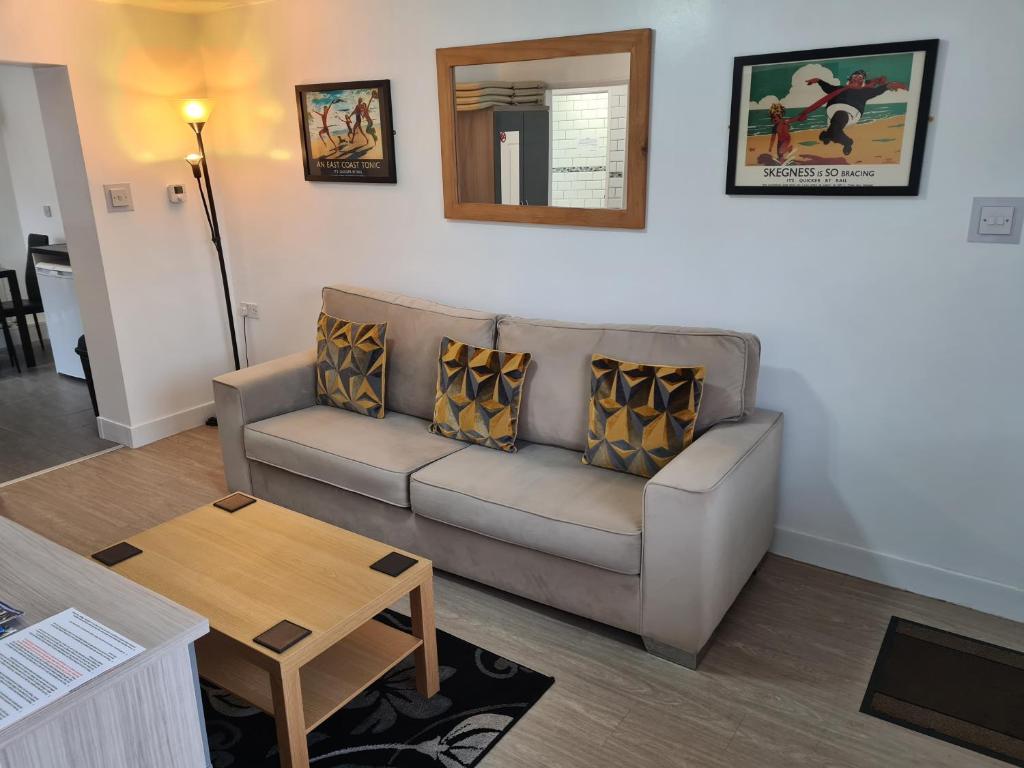 uma sala de estar com um sofá e uma mesa em North Parade Holiday Apartment 35 Sea View Road Skegness PE25 1BS em Skegness