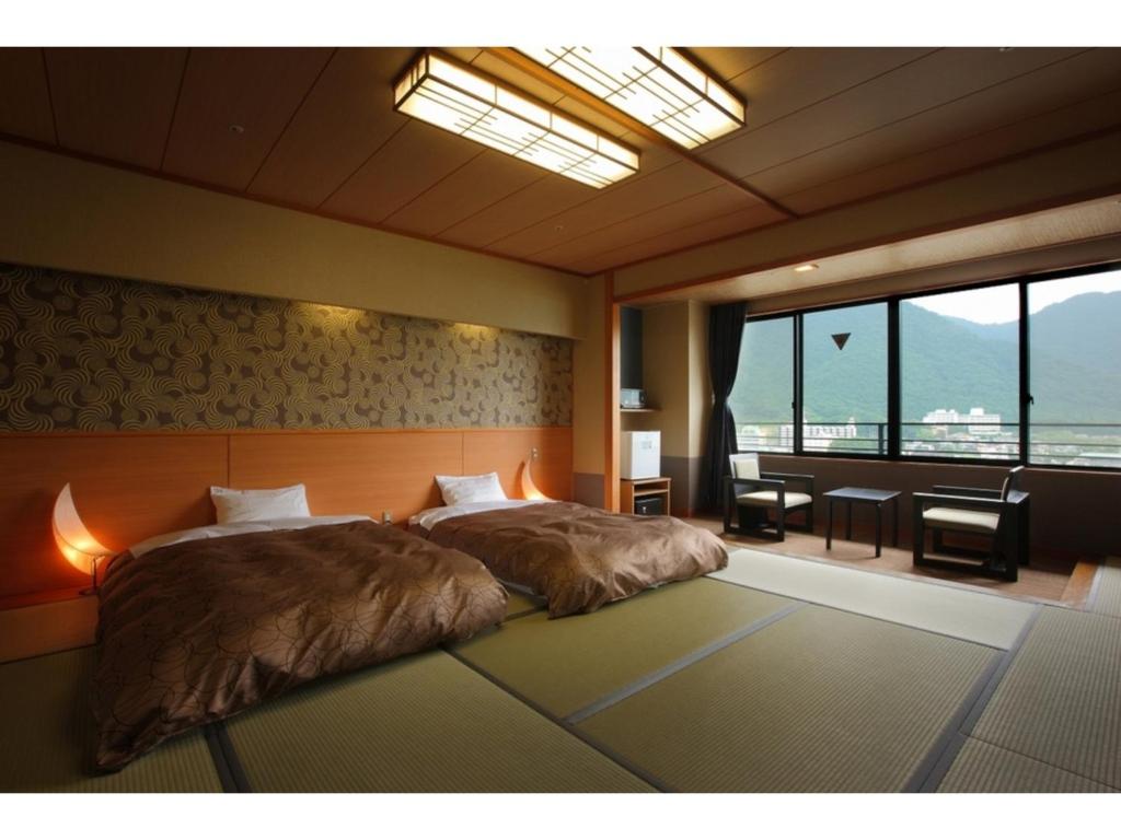 a bedroom with a large bed and a large window at Kinugawa Onsen Yusuikiko Hotel Otaki - Vacation STAY 68843v in Nikko