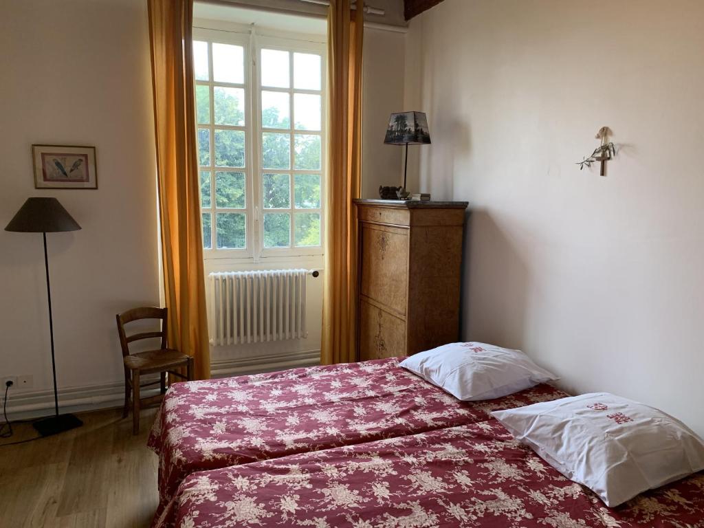 a bedroom with a bed and a window at Le Clos Saint Guilhem in Gerzat
