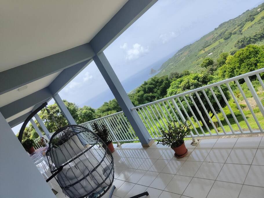 een balkon met uitzicht op een berg bij Bel appartement de 250 m² dans un coin de paradis in Marigot