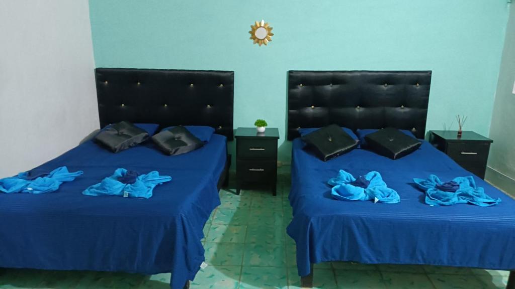 2 Betten in einem Zimmer mit blauer Bettwäsche in der Unterkunft Apto Yori: amplio y equipado. in Mérida