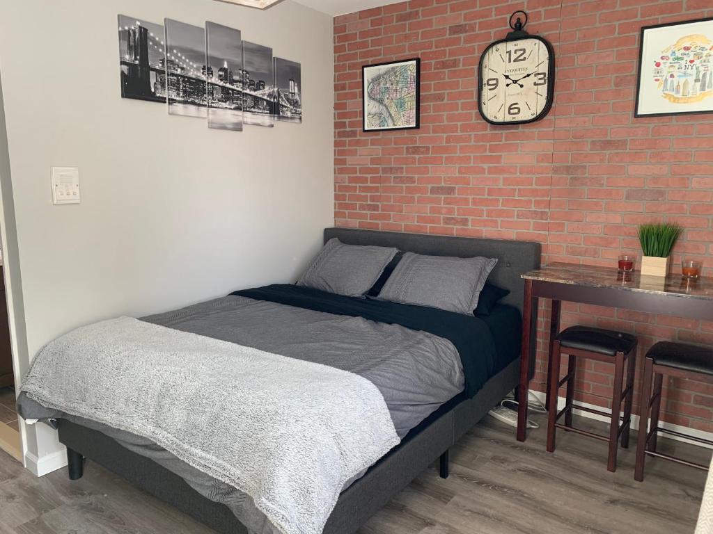a bedroom with a bed and a brick wall at Brooklyn Studios By The Beach in Brooklyn