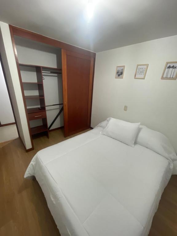 una camera da letto con un grande letto bianco di Apartamento en castropol a Medellín