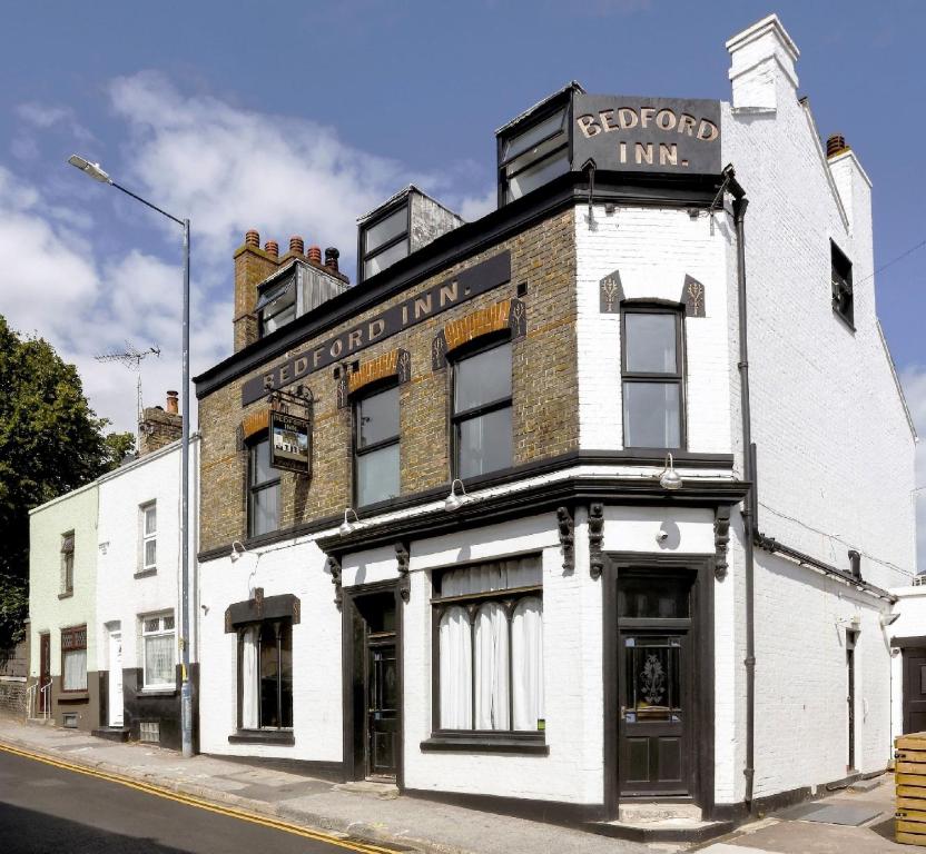 an old white building on the corner of a street at The Bedford Inn in Kent