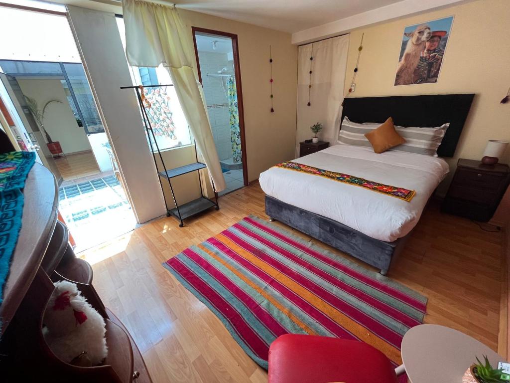 a bedroom with a bed and a colorful rug at Cusco Rooms in Cusco