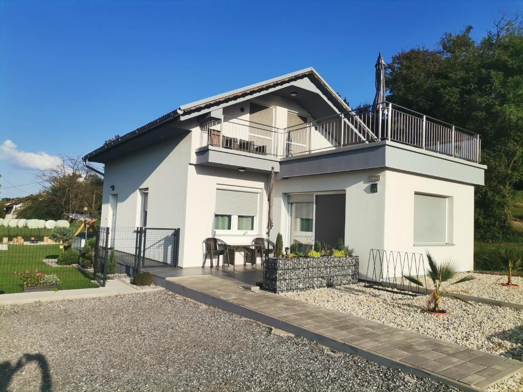 a white house with a balcony and a patio at Mali Portorož v Prlekiji in Ljutomer