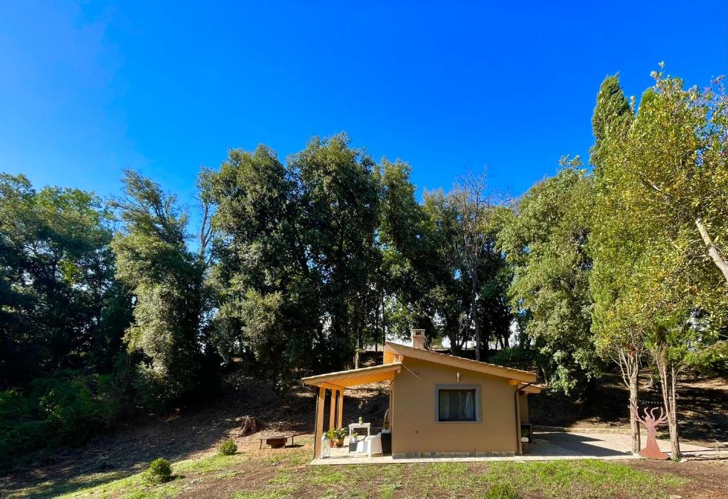 een klein huis in een veld met bomen bij La Marmotta COUNTRY RELAIS sul lago in Anguillara Sabazia