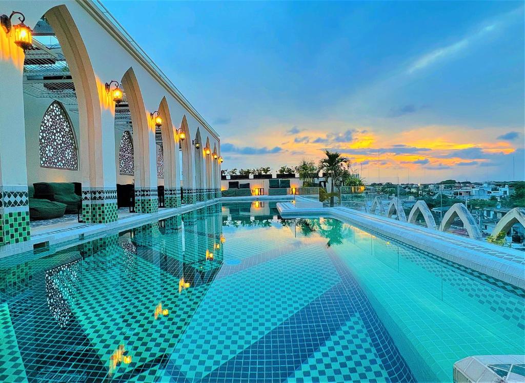 a swimming pool in a building with a sunset at Layla Tulum - Adults Only in Tulum