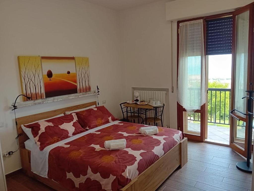 a bedroom with a bed and a balcony with a view at B&B la casa di Polly in Falconara Marittima