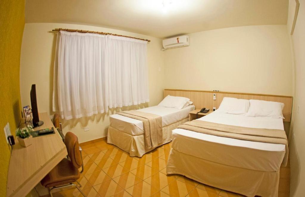 Postel nebo postele na pokoji v ubytování GoldMen Select Maringá