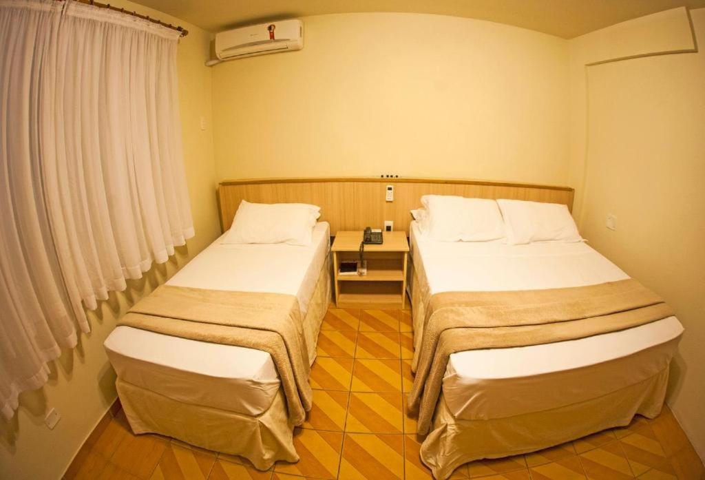 Postel nebo postele na pokoji v ubytování GoldMen Select Maringá