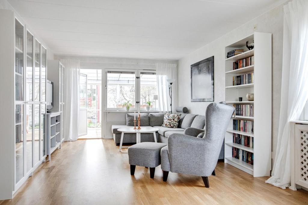 a living room with a couch and chairs and a table at comfortable room in a unique house at vikingavägen 75 in Gävle