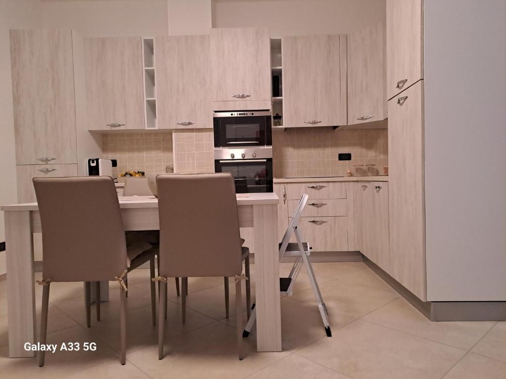 een keuken met een tafel met stoelen en een magnetron bij Da Marco in Budrio