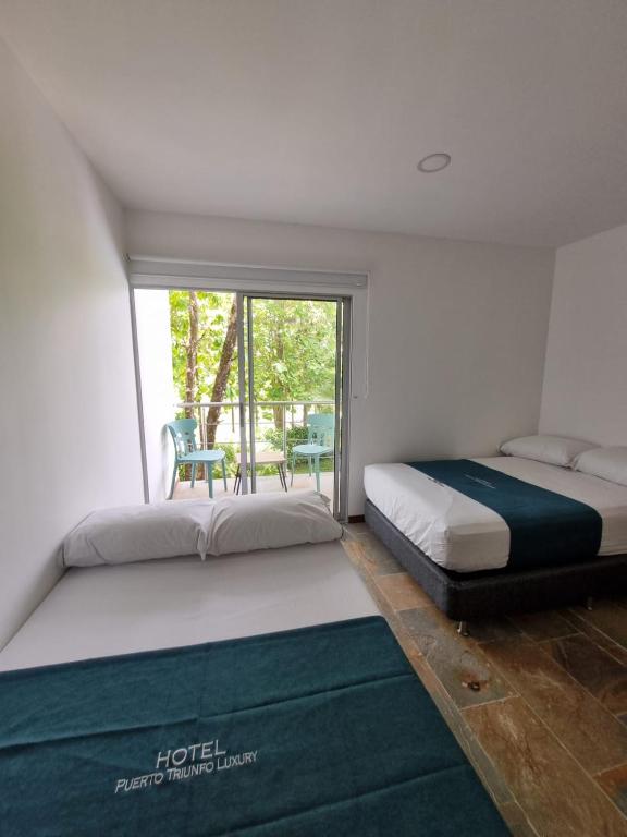 Postel nebo postele na pokoji v ubytování Hotel Puerto Triunfo