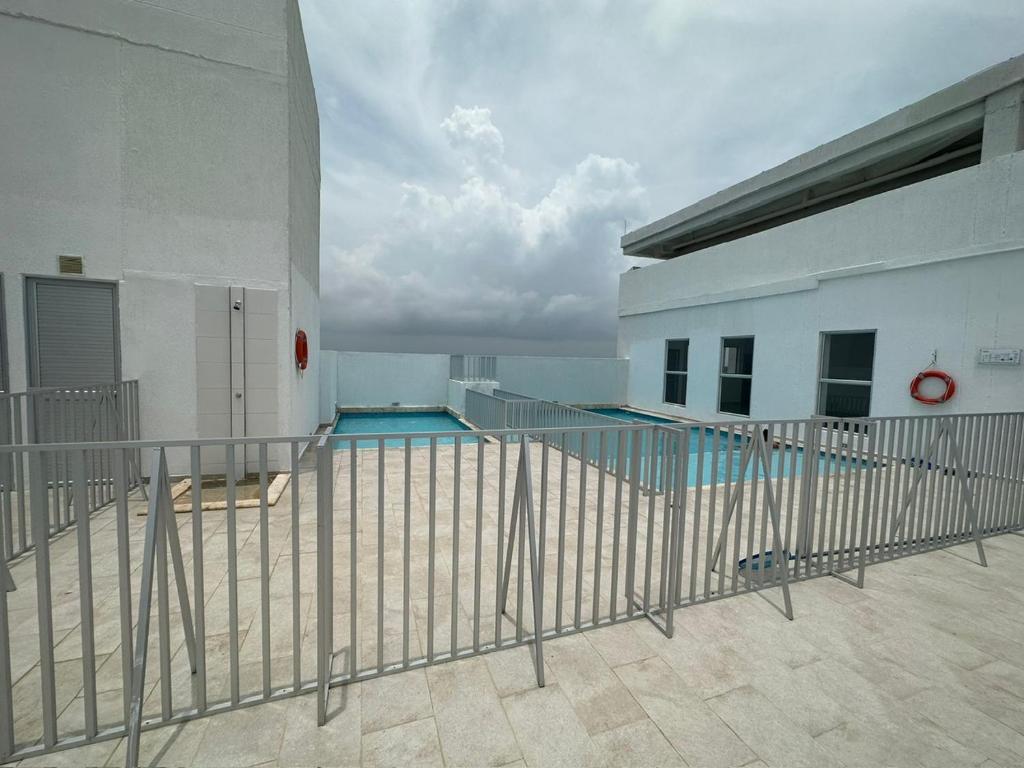 een zwembad naast een wit gebouw bij Apartamento Cerca al mar in Cartagena