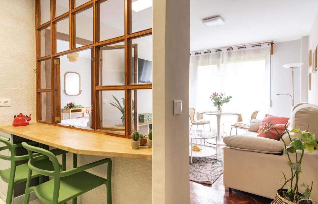 cocina y sala de estar con mesa y sofá en La casa del artista en Santander