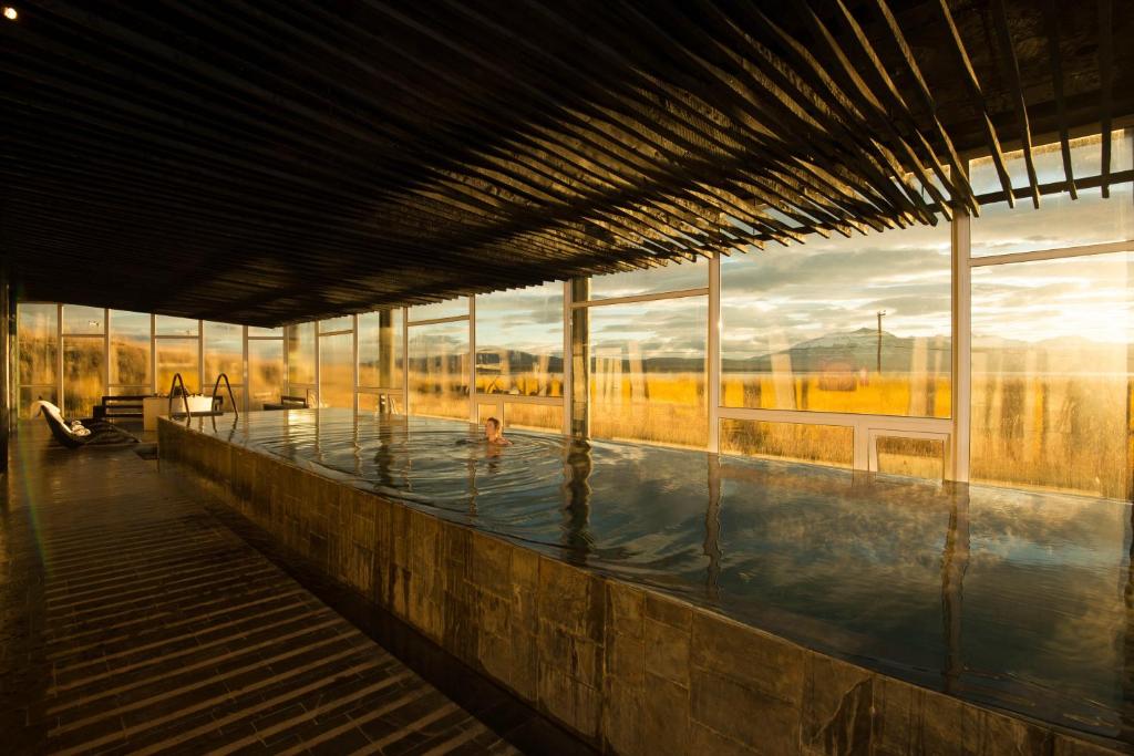 a swimming pool in a building with large windows at Remota Patagonia Lodge in Puerto Natales