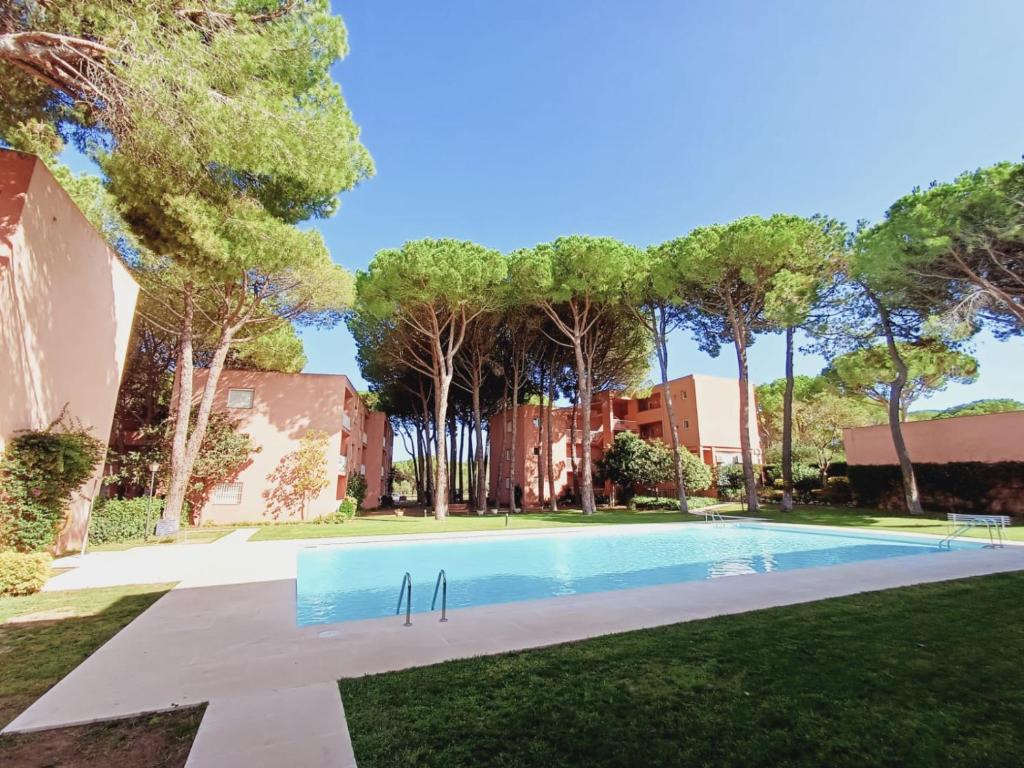 una piscina en un patio con árboles en Apartamento con piscina cerca de la playa, en Pals