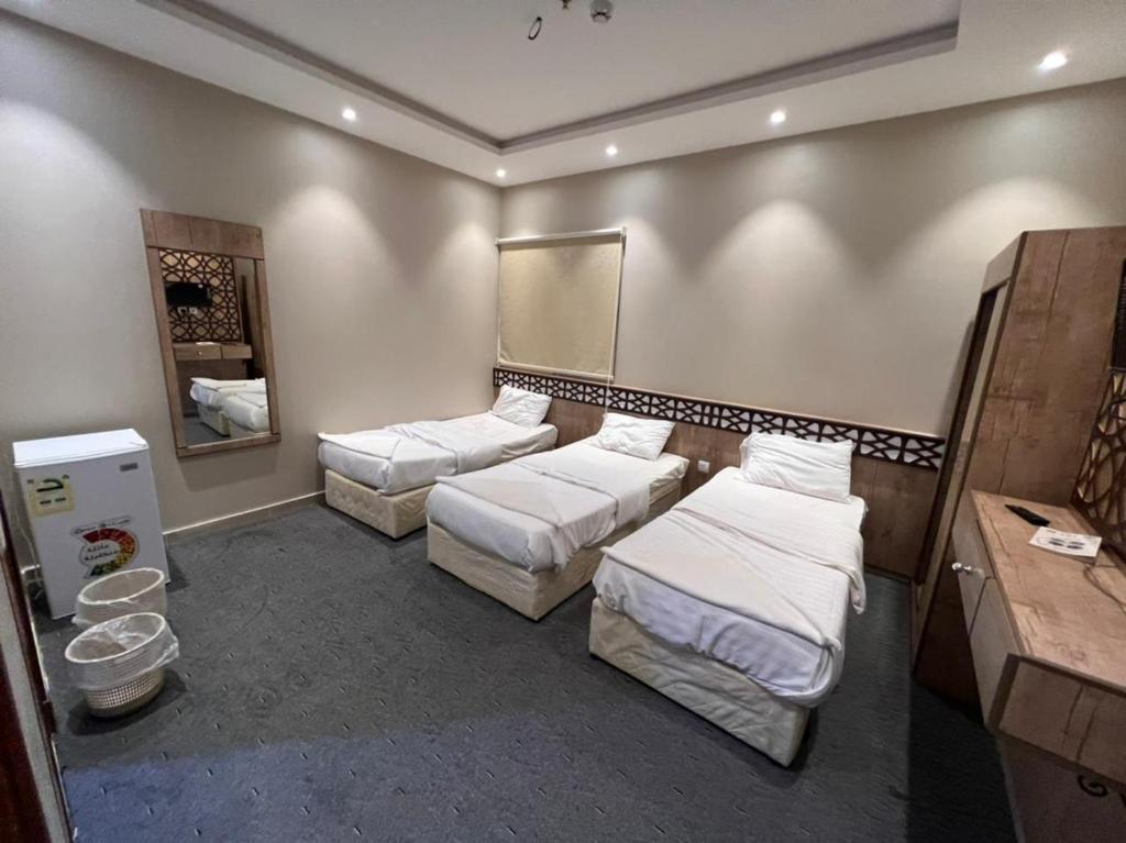 a room with two beds and a mirror at فندق قافلة الحجاز in Mecca