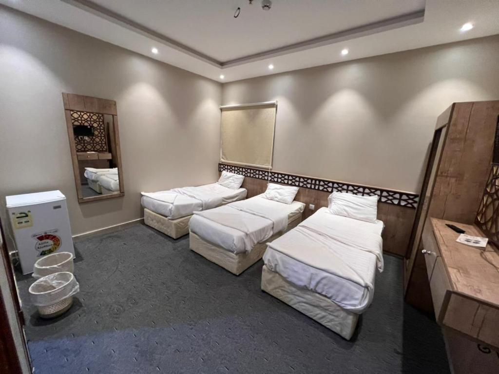 a room with two beds and a mirror at فندق قافله الحجاز توصيل مجاني الحرم مدى24 ساعه in Makkah