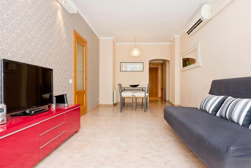 een woonkamer met een bank en een flatscreen-tv bij Glorias:Sagrada Familia 15 minutos - Playa 20 minutos in Barcelona