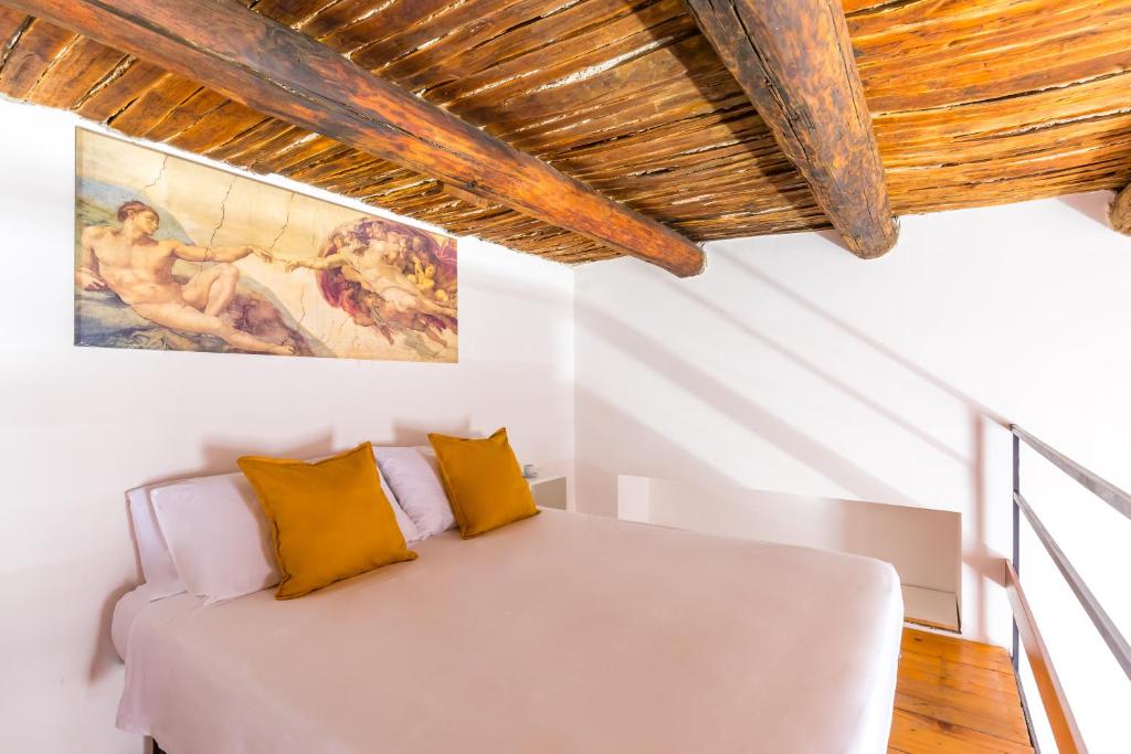een slaapkamer met een wit bed met gele kussens bij B&B Antica Napoli in Napels