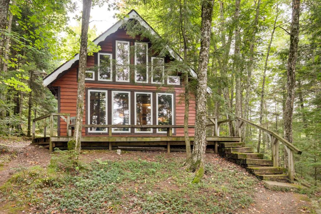 eine Hütte im Wald mit einer Treppe, die dorthin führt in der Unterkunft Tranquil Ogema Vacation Rental with Lake Views! 