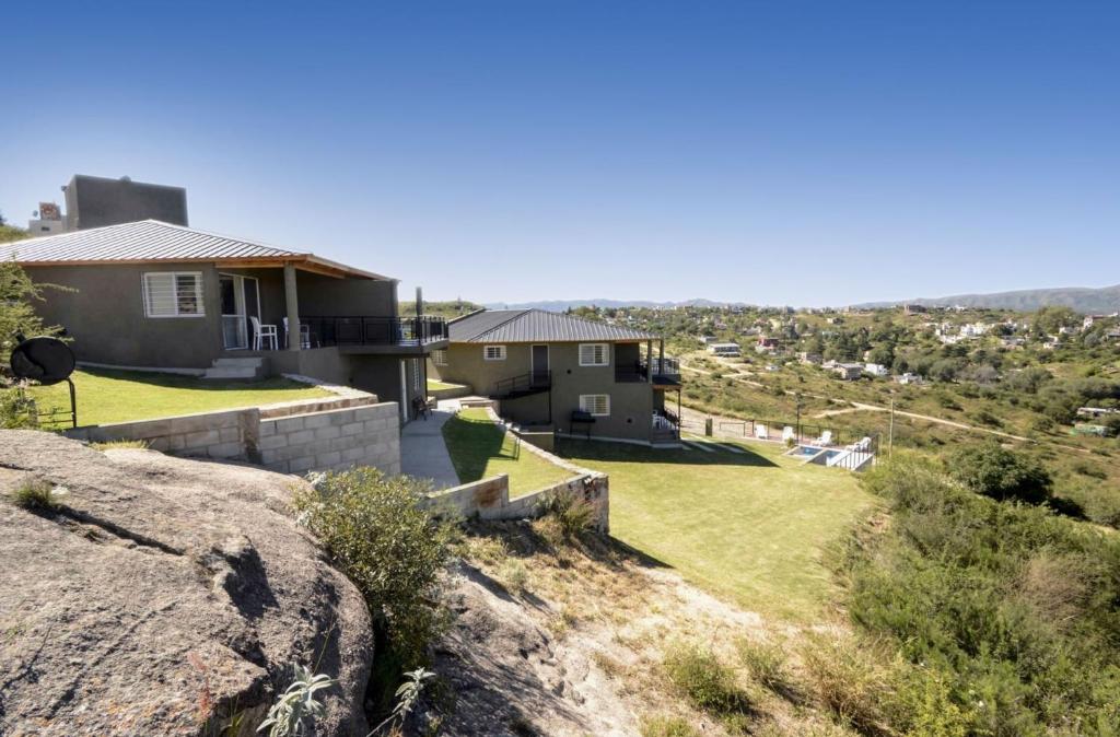 ein Haus an der Seite eines Hügels in der Unterkunft Complejo Lamarca in Villa Carlos Paz