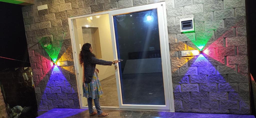 a woman standing in front of an open door at S B h in Gokarn