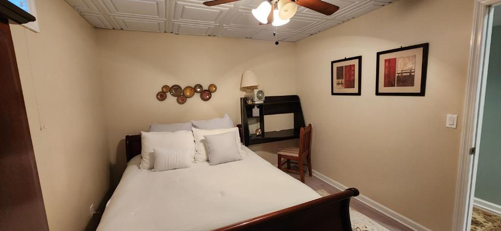 Schlafzimmer mit einem Bett mit weißer Bettwäsche und Kissen in der Unterkunft Comfortable, spacious, 1bdrm basement apartment, sleeps 4 in Milton