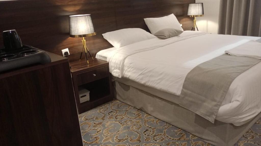 um quarto com uma cama grande e uma televisão em فندق الإحسان em Meca