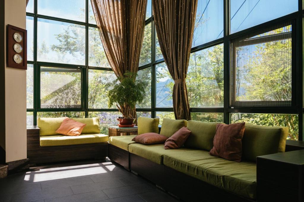 a living room with a couch in front of a large window at Yun Wu B&amp;B in Ren&#39;ai