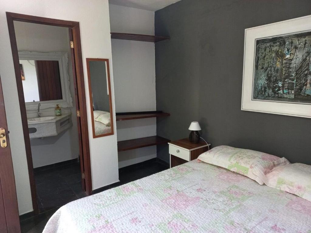 ブジオスにあるSuite Dupla em Búziosのベッドルーム(ベッド1台、シンク、鏡付)