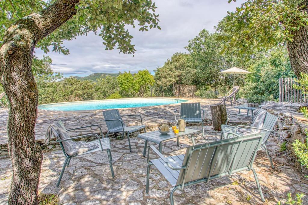 d'une terrasse avec des chaises et une table à côté de la piscine. dans l'établissement Maison La Hulotte, à Lussan