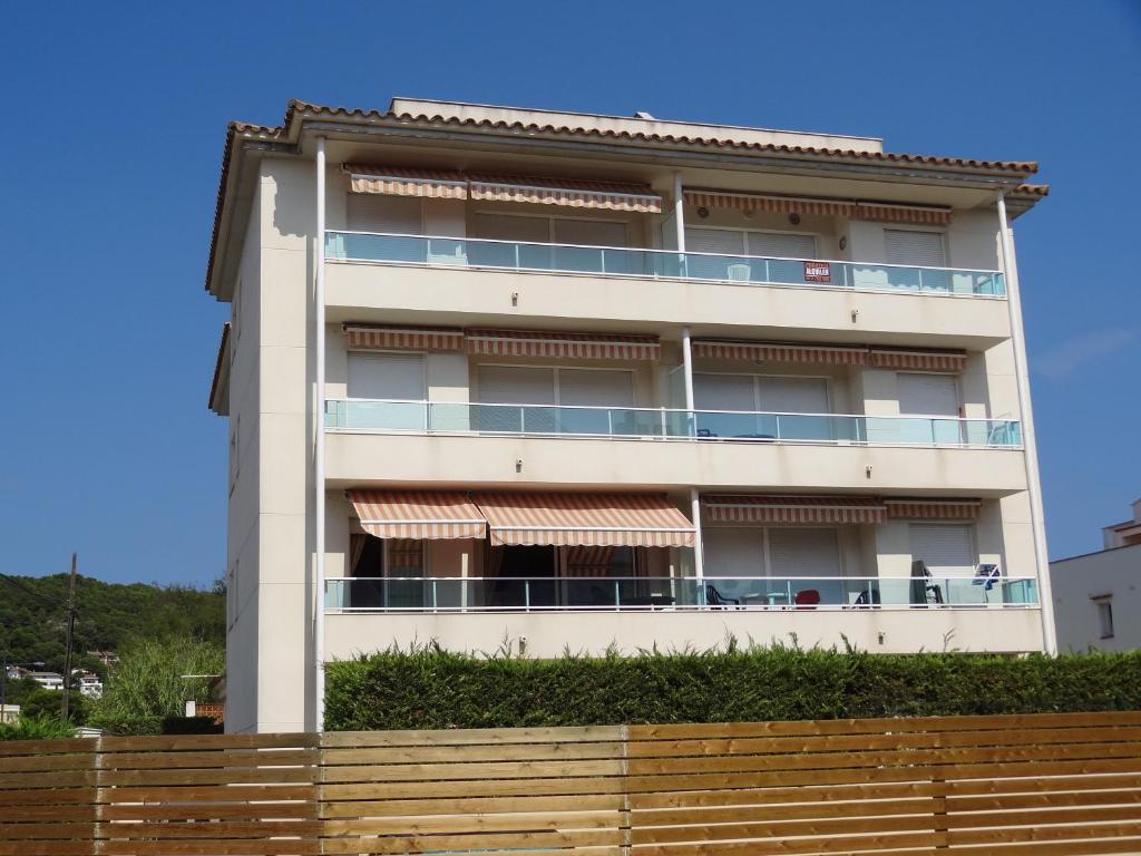 a white apartment building with a fence in front of it at Apartamentos Las Brisas in L'Estartit
