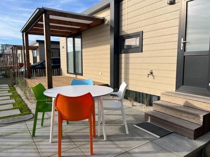 - une table et des chaises sur une terrasse avec une maison dans l'établissement Moderne chalet met airco in Blankenberge, à Blankenberge