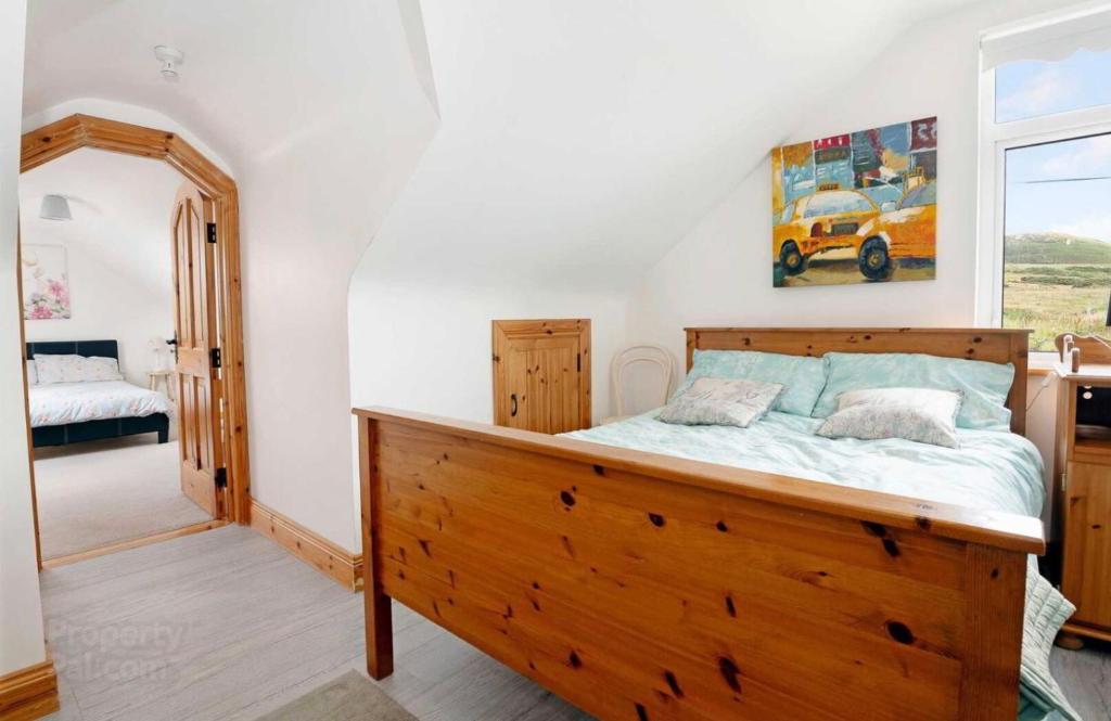 1 dormitorio con cama de madera en una habitación en Anne’s House en Dunfanaghy