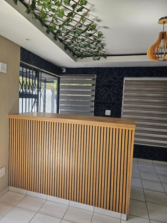 a lobby with a wooden counter in a room at YELLO GUEST HOUSE CE2 in Vanderbijlpark