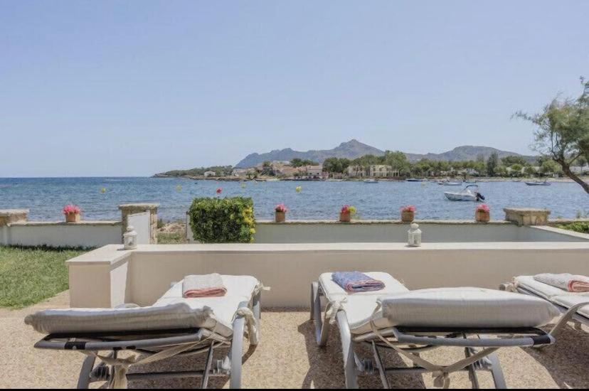un gruppo di sedie a sdraio sedute accanto a un corpo d'acqua di CASA PRINCESA a Alcudia