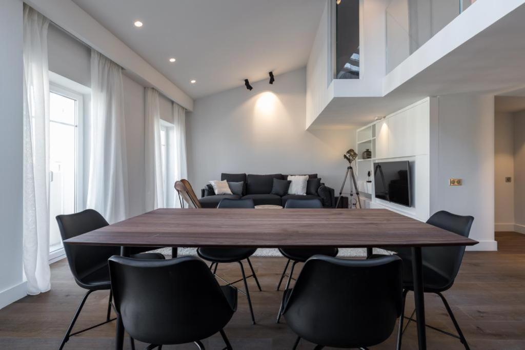 une salle à manger avec une grande table et des chaises en bois dans l'établissement Duplex Nice Avenue Jean-Médecin, à Nice