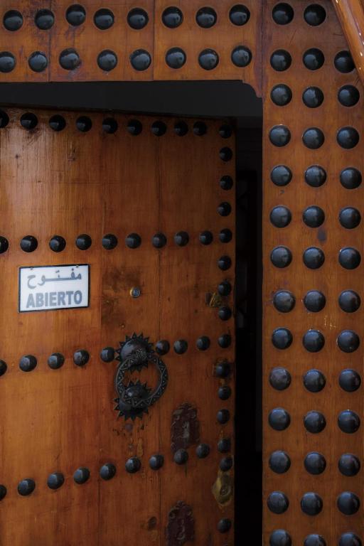 a wooden door with black beads on it at Hotel Blanco Riad in Tetouan