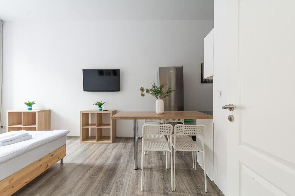 デュッセルドルフにあるT&K Apartments - 2 Room Apartment - Ground Floorのテーブル、椅子、テレビが備わる客室です。
