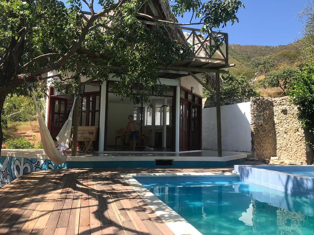 a villa with a swimming pool in front of a house at Villa Coco in Taganga