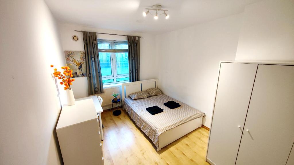 - une petite chambre avec un lit et un réfrigérateur dans l'établissement Spacious flat with 2 to 3 bedrooms in Central London, à Londres